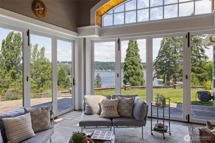 The sun room is a perfect place for entertaining, overlooking Tanglewood Island, with doors that fully open to the surrounding patio.