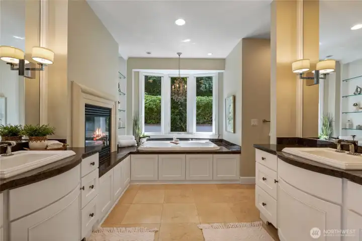 Primary bathroom features his and hers vanities, a gas burning fireplace and large walk-in closet
