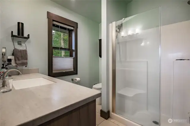 Oversize shower with custom glass doors.