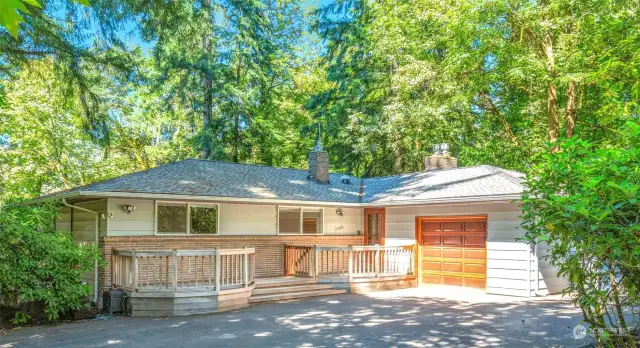 Surrounded by mature trees with horseshoe driveway.