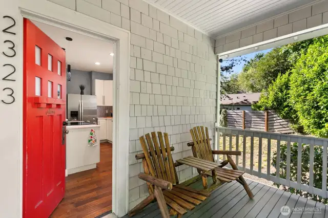 Welcome home! A cheerful red door opens to warm hardwood floors and a stylish kitchen. The front porch offers the perfect perch to relax beneath the shade of the trees.