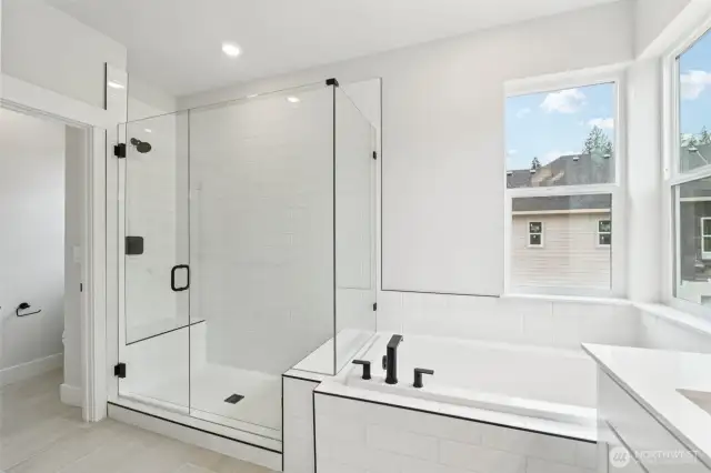 Soaking tub, frameless shower, extensive tile on floor and shower.