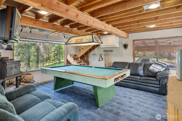 Pool interior! Wood burning free standing stove, obviously a pool table, microwave, seating area.