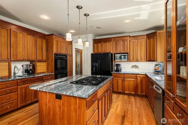 Custom cabinetry, granite slab, gas range and walk-in pantry.
