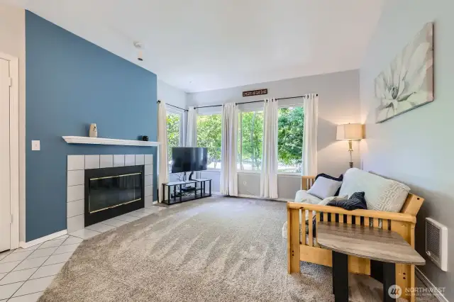 Living Room has Wood-Burning Fireplace with Tile Surround & Wood Mantle