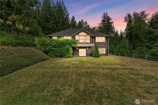 There is a spacious upper-level deck that offers an ideal spot for outdoor lounging and entertaining. Directly below the deck, a patio area provides a perfect transition from indoor living to outdoor. The lower patio is easily accessible from the downstairs level and extends out onto the private backyard. These spaces are perfect for gatherings, outdoor dining, or simply enjoying the mountain view and peaceful landscape