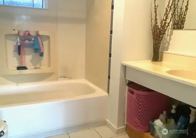 Main bathroom with soaking tub and tiled floor.