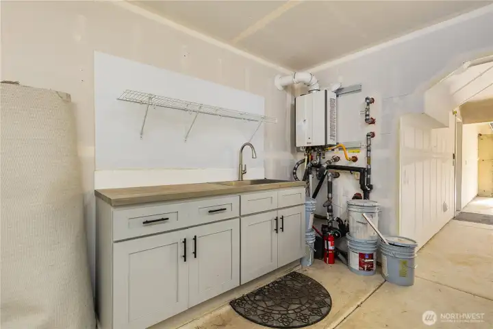 Full sink next to the tankless water heater in the garage.