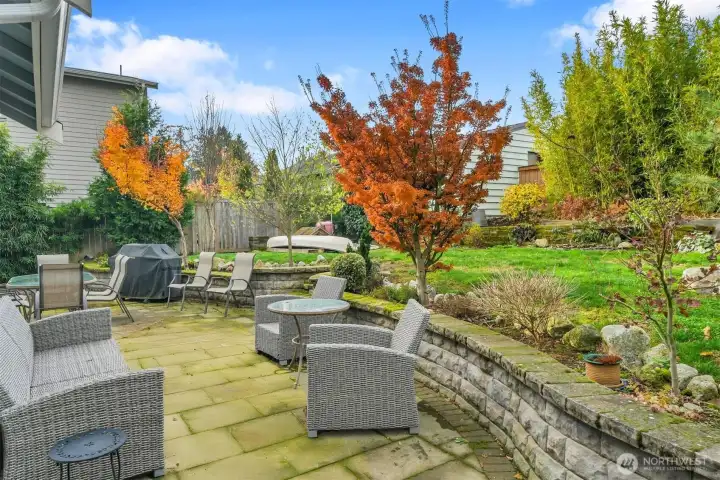 Landscaped back yard with stone patio and rock walls