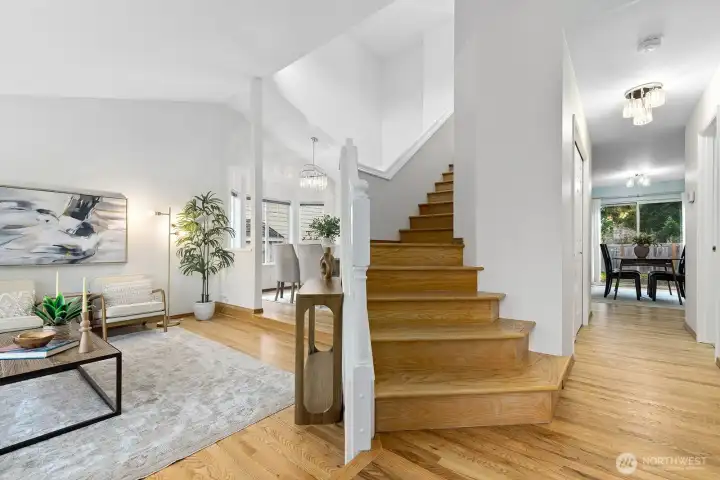 Dramatic entry with open staircase and freshly refinished hardwood floors.
