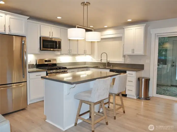 Stylish Kitchen w/ Island, Quartz counters, SS Appliances, Propane Range, and lots of lighting.