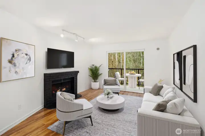 The living room includes a cozy wood burning fireplace and terrace overlooking a wooded open space. Virtual staging.