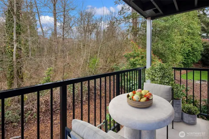 The exterior terrace overlooks a wooded open space and includes a large storage closet.