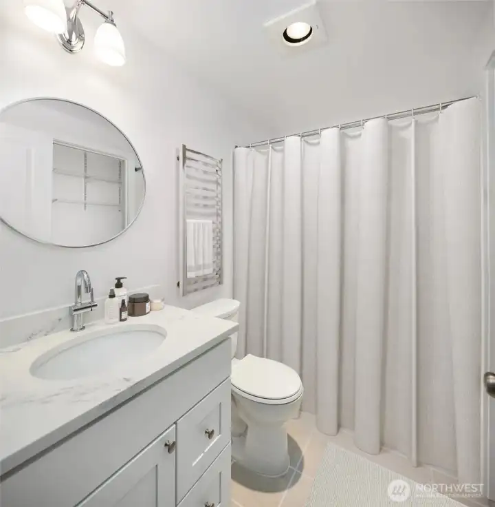 The large bathroom includes a new bath vanity, sink, quartz countertop, toilet and refreshed ceramic tile surround and bath floor. Virtual staging.