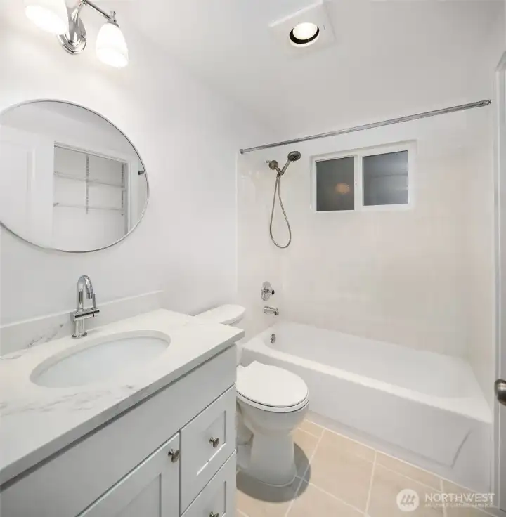 The bathroom includes ceramic tile tub/shower surround and ceramic tile floor.  New cabinet, sink, quartz countertop and toilet.  Bath window opens for lots of fresh air!