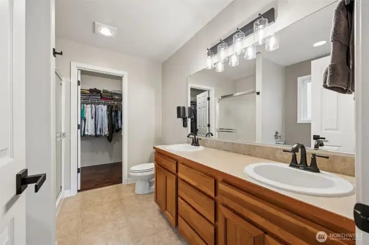 Double vanities in the primary bath with a walk in closet.