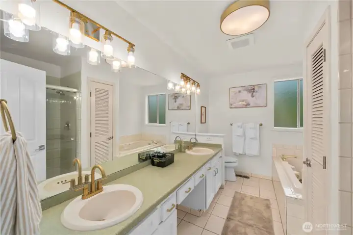 Primary bathroom features a jetted tub, shower and dual vanities.