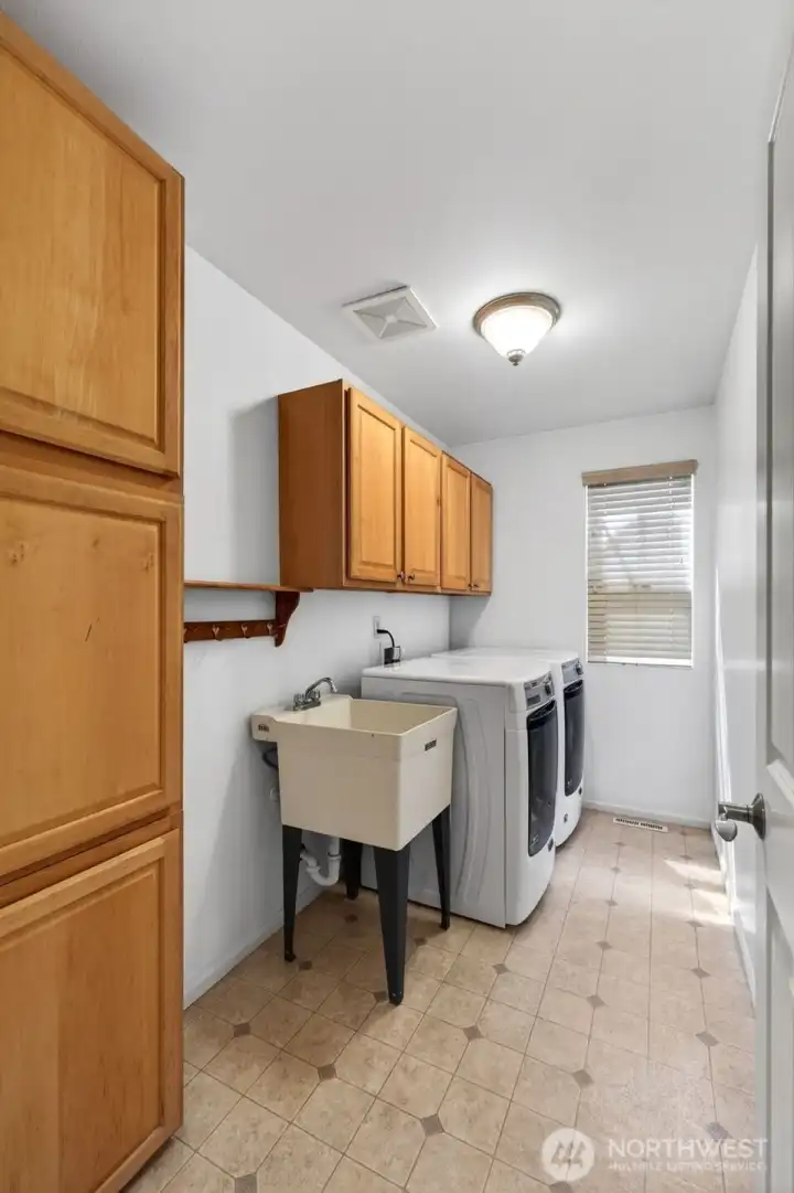 Laundry room with storage and a sink