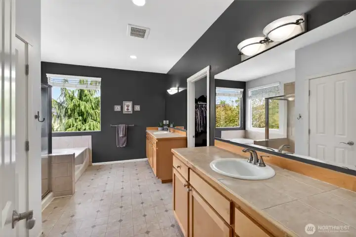 Primary bathroom features a soaking tub, separate vanities, walk-in closet and private toilet room