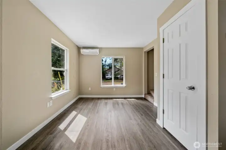 Dining room area with dual split heating/cooling unit. Door to closet storage that goes under the stairs.