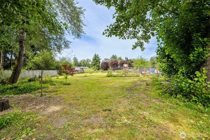 Incredible fully fenced back yard with playset (stays) and fenced chicken area.