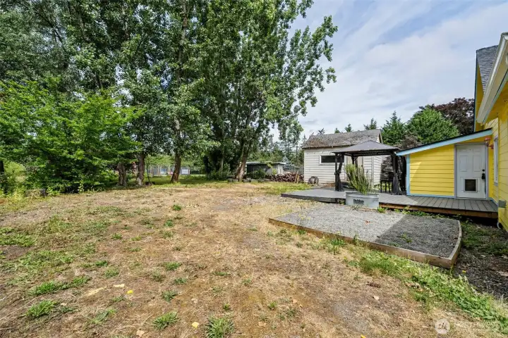This  portion of the yard was used for parking so grass is in rough shape. Nice deck with covered area (stays with purchase) and shed.