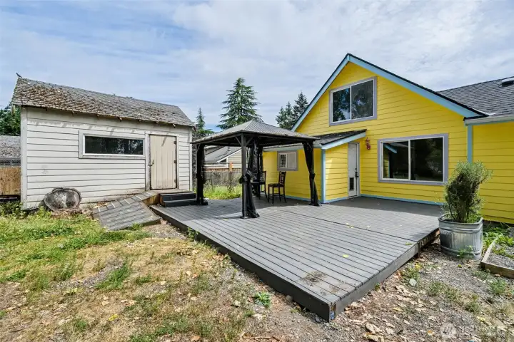 Back yard deck with covered area (stays) and shed.