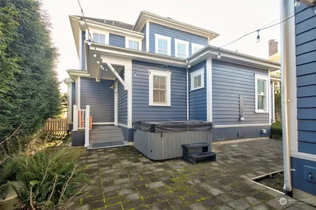 The back of the home is private and has custom pavers and hot tub with outdoor shower.