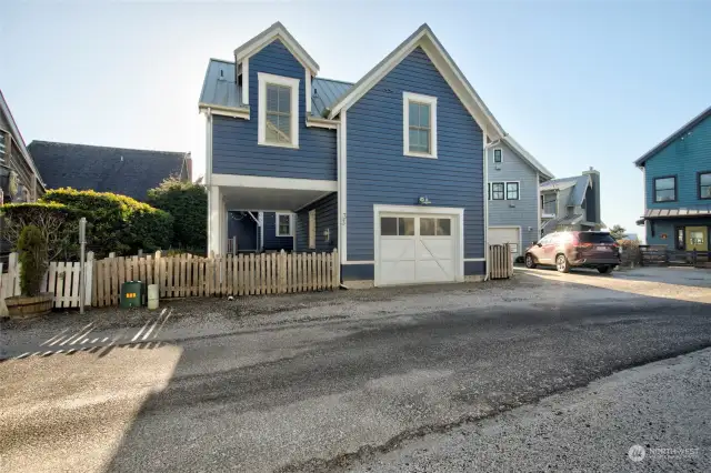 View of the carriage house from Fireside Lane showing the single car garage and carport.