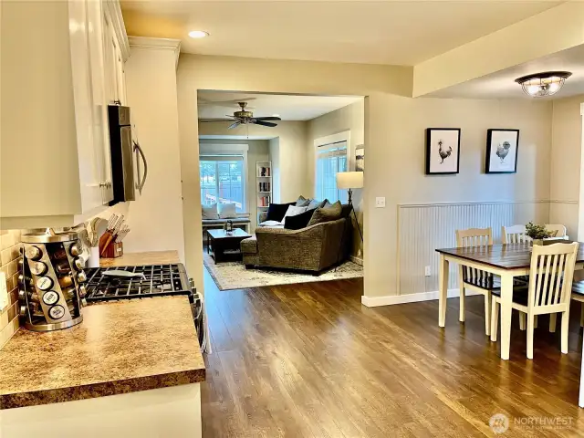 A seamless view of the kitchen, dining room, and living room, showcasing an open, inviting layout.