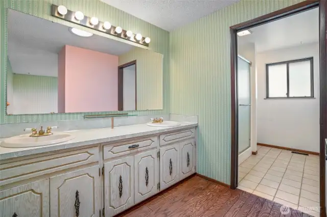 The primary bath includes double sinks and a separate shower and toilet area.