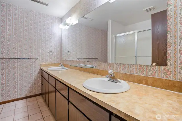 The lower-level bath room with tile floors and double sinks.