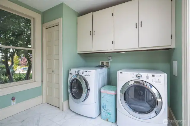Laundry room with great storage, marble tiled flooring, and sliding glass to embrace all the light and provide access the South-facing deck and private backyard.