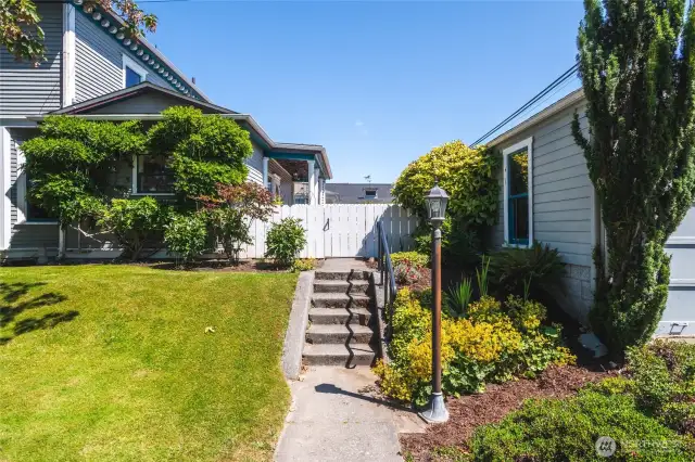 Lovely gardens and entry to private, fenced backyard with a rose garden, spacious sundeck, shop, alley access and one car garage as well as an additional storage room. Consider the possibility of creating an ADU!