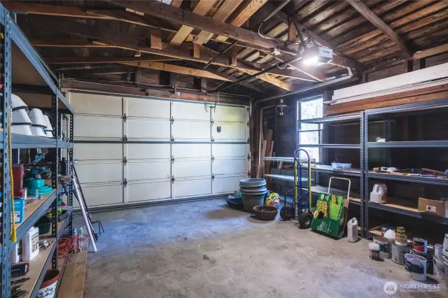 Oversized one-car garage with lots of shelving for additional storage.