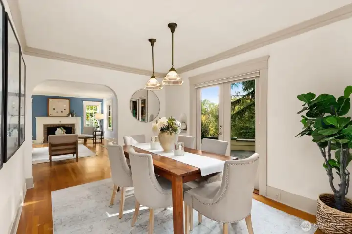 Elegant and open, the dining room connects living and kitchen spaces with French doors leading to an outdoor terrace surrounded by trees.  When appropriate, why not invite the outdoors to your dinner party?  The flow from the dining room french doors to the kitchen french doors provides a lovely flow for guests.