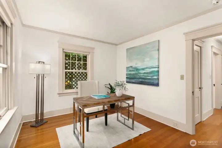 A light-filled office with hardwood floors located just off the kitchen at the back corner of the home offers quiet inspiration for work or creativity.