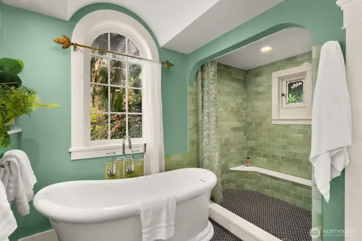 Recently remodelled, this spa-inspired retreat features a new soaking tub beneath this arched window makes a fantastic statement.  The handmade tile for the walk in shower, featuring a thermostatic shower head, brings the feel of nature into the space.