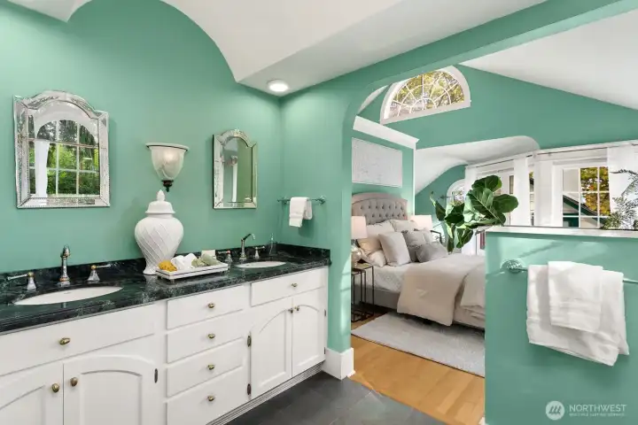 Dual vanities with vintage-inspired mirrors, and arched architecture complete this serene and sophisticated ensuite.  Reveal:  the sinks here have a dedicated on-demand water heater.