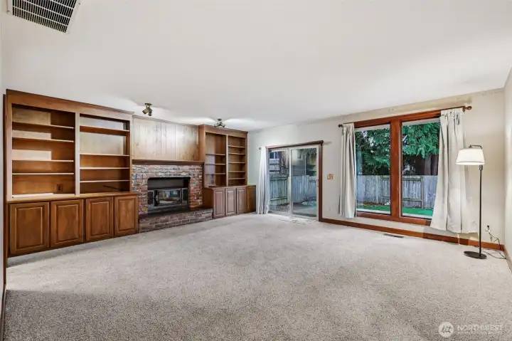 A spacious family room with built-ins and a gas fireplace for cozy winter nights (central AC for summer!). It also has access to the backyard.