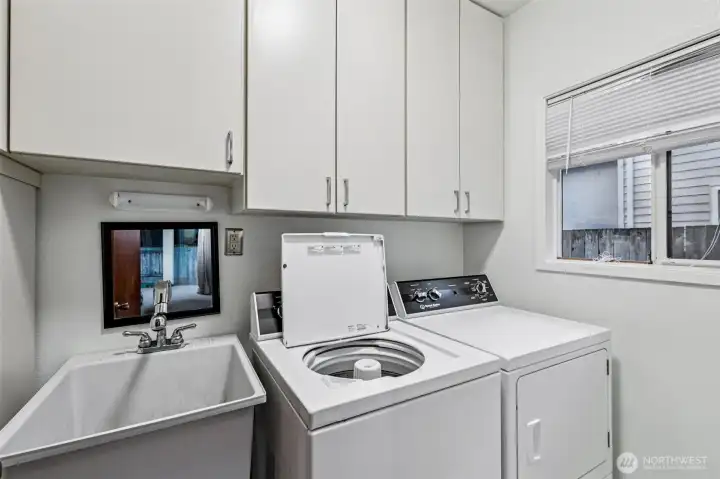 Laundry room with utility sink and storage.