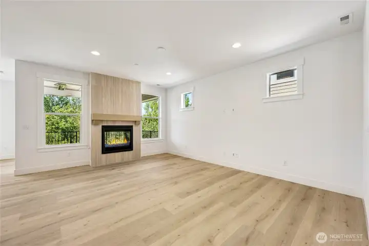 dramatic double-sided fireplace with trees out every window