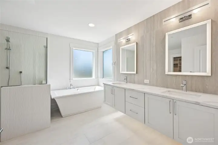 Spa-like ensuite complete with heated floors, soaking tub, huge walk-in shower, back lit mirrors, and floating vanities