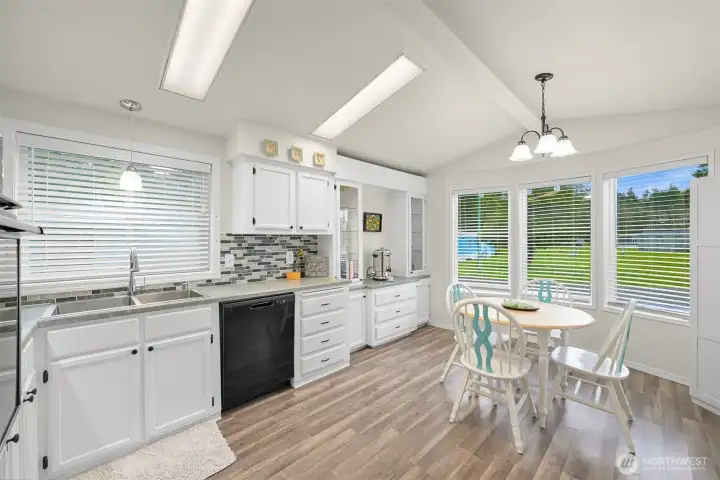 Bright kitchen has newer fridge and dishwasher.