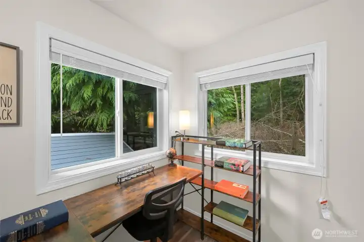 Corner nook in bedroom makes a great office space, with a pretty view of woods behind.