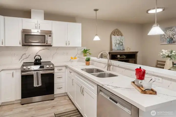 Quartz surfaces and breakfast bar create a clean, functional space that connects to the living area.
