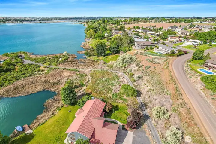 The property is the farther half of the two lots between the house and the gravel access road. The property is the farther half of the two lots between the house and the gravel access road.