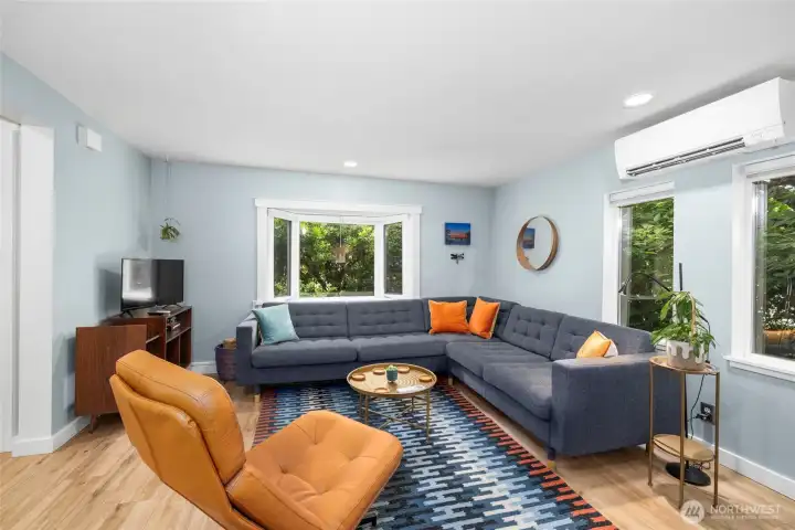 Living room with fresh paint & trim, LVP flooring. A garden window showcases the private gardens and welcome nature's beauty inside.