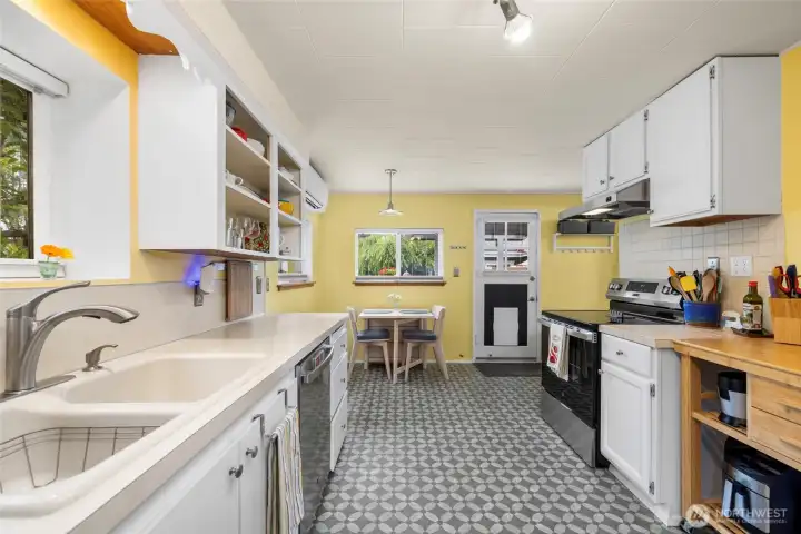 Adorable kitchen offers good prep space, freshly painted cabinets, newer appliances and I love this flooring!! So cute!