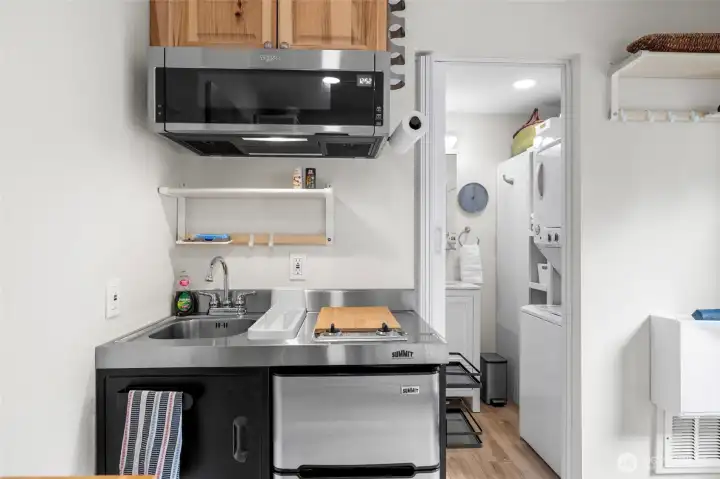 Kitchenette with cooktop, microwave, sink and frig. So well designed.